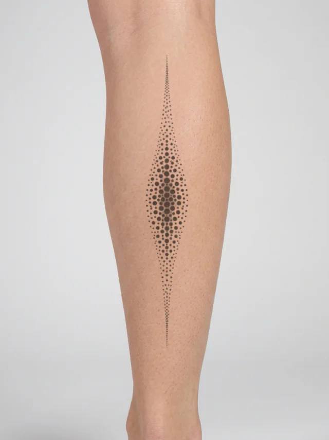 Tatuaje de ornamento de puntos en la pantorrilla, en la piel