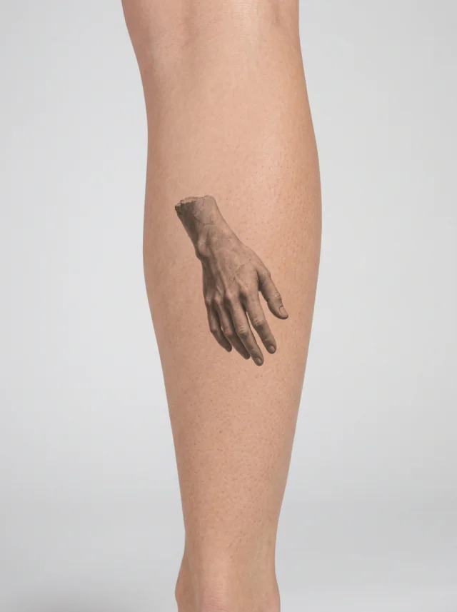 Tatuagem de mão esculpida na panturrilha, aplicada na pele